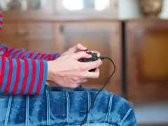 Ręce trzymające kontroler, gotowe do gry. Dowiedz się, jak podłączyć pada od Nintendo Switch do PC, by cieszyć się grami na większym ekranie.