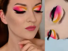 Oczy z wyrazistym makijażem cut crease w odcieniach różu, pomarańczy i żółci. Czarne kreski i długie rzęsy podkreślają spojrzenie.
