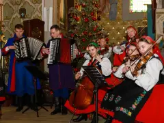 Zespół w strojach ludowych grający wszystkie kolędy polskie przy choince.
