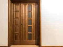 Puertas dobles de madera con paneles y vidrio, ideales para inspirarte sobre como elegir el color de las puertas de interior.