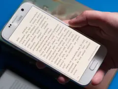 Dłoń trzyma smartfon, na którym wyświetlona jest książka do czytania na telefonie.