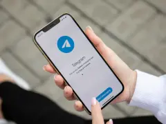 Dłoń trzyma smartfon z otwartą aplikacją Telegram. To szybka i bezpieczna apka do wysyłania wiadomości.