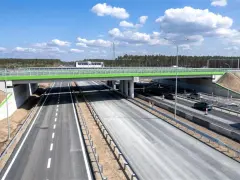 Nowa autostrada A6 z zielonym wiaduktem i ruchem samochodowym.