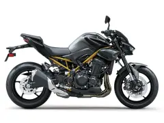 Stylowy, czarny Kawasaki Z900 z widoczną złotą ramą, gotowy na podbój dróg.