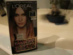 Pudełko farby L'Oréal Préférence z efektem czarne włosy ombre. Modelka na opakowaniu ma włosy w odcieniach brązu i blondu.