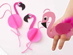 Pink paper flamingos, perfect for flamingo basteln! One is worn on a hand like a puppet, adorned with a fluffy pink feather.
