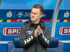Trener Motoru Lublin, który pokaże ekstraklasę, z dłońmi złożonymi w geście nadziei.