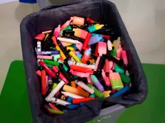 Contenedor lleno de vapes desechables de colores. ¿Qué hacer con un vape desechable? Reciclaje responsable.