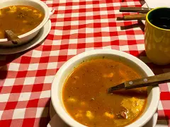Dwa talerze gulaszu i żółty kubek kawy na czerwono-białej kratce. Zastanawiasz się, ile kosztuje obiad w Budapeszcie?