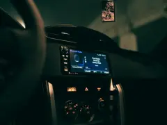 Wnętrze samochodu z włączonym radiem, na ekranie wyświetla się "Bluetooth Audio" i tytuł piosenki. Zastanawiasz się, co to jest treble w kontekście dźwięku? To wysokie tony.