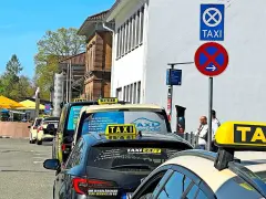 Taxistand mit Schildern. Was kostet eine Taxifahrt von 30 km? Die Schilder geben keine Auskunft über Preise.