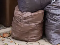 Brązowe i ciemne worki na śmieci, niektóre z napisem "BIO". Czy odpady bio można wyrzucać w workach? Tak, jeśli są to specjalne worki do tego przeznaczone.