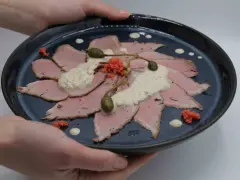 Vitello Tonnato: hauchdünne Scheiben Kalbfleisch, belegt mit cremiger Thunfischsauce, Kapern und roten Kaviar-Kügelchen.