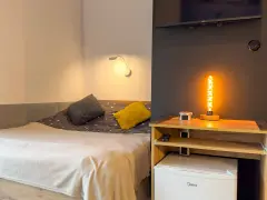Przytulny pokój z łóżkiem, ozdobną lampą i lodówką. Idealne miejsce na **weekend w Karpaczu**.