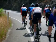 Cyclists in racing gear tackle a steep road, their shadows stretching long on the asphalt. This is the essence of category climbs cycling.