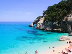 Cala Goloritze: turkusowa woda, skaliste klify i plażowicze cieszący się słońcem.