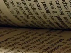 Páginas de un libro abierto, con texto en inglés. Se lee "old", "bad", "fashion", "throat", "around", "because", "often", "exp".