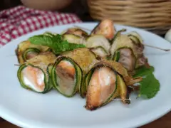 Deliziosi involtini di zucchine con salmone e formaggio, guarniti con menta fresca.