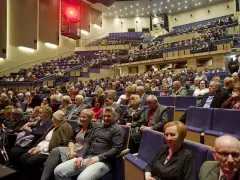 Widownia sali koncertowej, ludzie w eleganckich strojach, inspiracja: jak ubrać się na koncert muzyki filmowej.