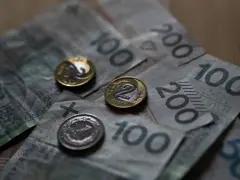 Złotówki na stole. Czy umowa zlecenie wlicza się do emerytury? Pieniądze i monety symbolizują przyszłość.