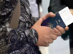 Dłoń trzyma paszport i bilet lotniczy. Czy przy zakupie biletu lotniczego potrzebny jest paszport? Tak, do podróży zagranicznych.