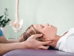 Delikatna terapia krzyżowo czaszkowa dla ulgi w napięciu. Terapeuta delikatnie uciska głowę pacjentki.