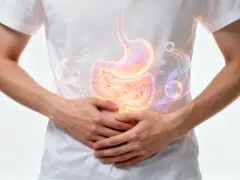 Ein Mann hält sich den Bauch, auf dem Magen und Darm leuchten. Bläschen und Rauch deuten auf ein Gluckern im Bauch hin.