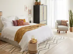 Cama acogedora con mantas y cojines, ideal para un ambiente de feng shui.