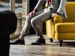 Eleganckie, ciemnobrązowe buty męskie do szarego garnituru w kratę. Stylizacja idealna na co dzień i specjalne okazje.