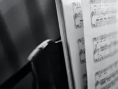 Spartito musicale aperto, con note e indicazioni di tempo, evoca le grandi colonne sonore che hanno segnato cinema e TV.