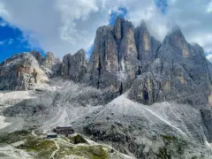 Rifugio alpino ai piedi di imponenti vette dolomitiche, ideale per un trekking di 5 giorni.