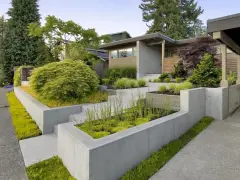 Modern entré inspiration utomhus med betongmurar, trappor och frodig grönska. En inbjudande och stilren design.