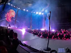 James Hetfield śpiewa na koncercie Metalliki w Warszawie. Tłum szaleje, a gigantyczny ekran pokazuje zbliżenie na wokalistę.