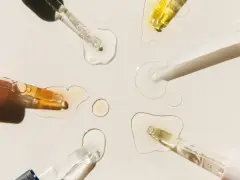 Krople serum i pipetki na jasnym tle.