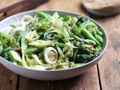 Zielona sałatka z pak choi, groszku cukrowego i cebuli, posypana sezamem. Idealna do dań kuchni azjatyckiej, świetne kapusta pak choi przepisy.