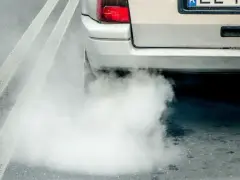 Z tyłu samochodu wydobywa się biały dym. Widać fragment tylnej lampy i tablicy rejestracyjnej. Diesel kopci na biało.