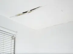 Widoczne pęknięcia na suficie w starym domu, świadczące o jego wieku i potrzebie remontu.