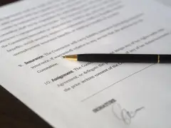 Długopis leży na dokumencie, gdzie widnieje nagłówek "umowa użyczenia lokalu" i miejsce na podpis.