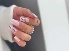 Delikatne, **milky nails** w odcieniach różu, ozdobione czarnymi napisami "smile" i "our moment".