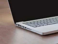 Czekam na inspirację, gdy czarny ekran w laptopie odbija światło.