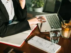 Pracownik biurowy przy laptopie, obok notatnik "To Do List", szklanka wody i kawa. Zastanawia się, ile czasu ma bank na zwrot prowizji.