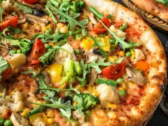 Pyszna pizza bez mięsa z brokułami, pomidorkami, kukurydzą i rukolą. Idealna dla wegetarian.
