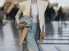 Elegancka stylizacja: jak nosić kamizelkę damską z szerokimi spodniami i błękitną torebką.