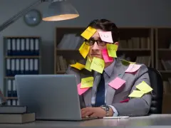 Homme submergé par des post-its, symptômes de burn out. Médecine du travail à considérer.