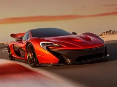 Czerwony McLaren P1 pędzi po pustynnej drodze o zachodzie słońca.