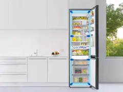 Otwarta lodówka Samsung z jedzeniem i szufladami, w nowoczesnej kuchni.