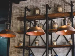 Industrialne lampy wiszące nad półkami ze słoikami. Dowiedz się, jak wyczyścić abażur z lampy, by odzyskał dawny blask.