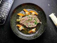 Zarter Tafelspitz braten im Topf, serviert mit Karotten und Lauch. Frisch geriebener Meerrettich daneben.