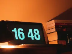 Na ekranie laptopa 16:48. Obok stos książek, w tym "#socialholic". Ile przerwy na 12 godzin pracy?