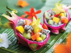 Smoczy owoc w formie miseczki wypełnionej egzotycznymi owocami: kiwi, mango, papają i karambolą.